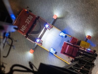 Blick von oben auf eine rote Feuerwehr-Drehleiter auf einem Hof mit gepflastertem Boden.